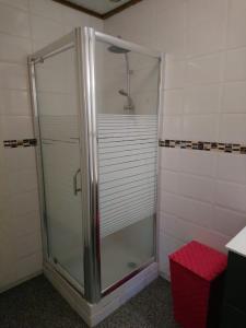 una cabina doccia in un bagno con uno sgabello rosso di Charmant bungalow F3 sur la plage de petite anse, Bouillante a Bouillante