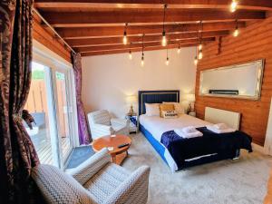 1 dormitorio con 1 cama, mesa y sillas en Kaoglen Squirrel Drey-Hot Tub-Pet Friendly-Perth, en Balnald