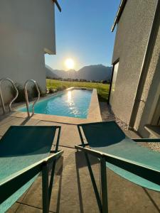 una piscina con due sedie accanto a un edificio di Urban Mountain Chalet with Lake View a Maurach