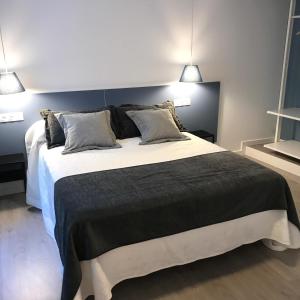 a bedroom with a large bed with two lamps at Nest Flats Santiago VUT in Santiago de Compostela