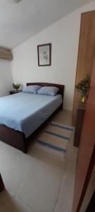 a bedroom with a bed with blue pillows on it at Guest house Ruzica in Sutomore