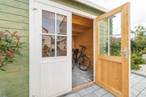 an open door to a house with a bike outside at Ferien-Apartment Beller in Strullendorf