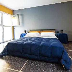 a large bed with a blue comforter in a bedroom at Marathon Hostel in Genova