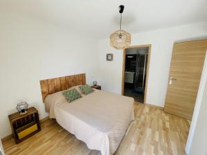 1 dormitorio con 1 cama y suelo de madera en Ajaccio T2 grand standing neuf - centre ville et plages - 4 personnes - parking privé, en Ajaccio