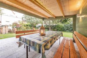 a table with a lamp on a patio with benches at Ferien-Apartment Beller in Strullendorf
