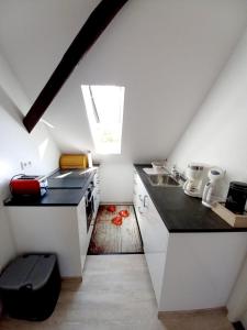 a small kitchen with white cabinets and a window at FeWo Weser in Hadamar