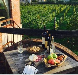 einen Tisch mit Flaschen Wein, Brot und Trauben in der Unterkunft Resort La Ghiaia in Sarzana