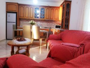 a living room with a red couch and a table at Eva's House in Lukovë