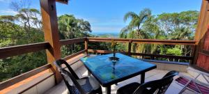 uma varanda com mesa, cadeiras e árvores em Casa do Mirante quarto 303 em Florianópolis