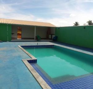 una grande piscina di fronte a un edificio verde di Pousada Peruaçu & Restaurante a Fabião