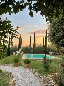 a garden with a swimming pool and trees at Pieve mirabella - casa con vista panoramica in Città della Pieve
