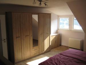 una camera da letto con un grande armadio in legno con specchio di Haus Beate Groß a Kröv