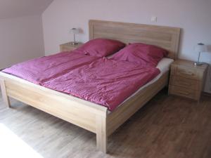 a large bed with purple sheets and two night stands at Haus Beate Groß in Kröv