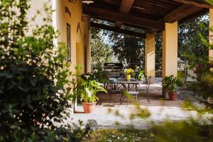 a patio with a table and chairs and plants at Agriturismo Montalbino in Montespertoli