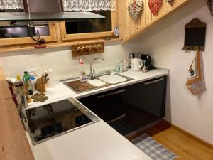 a small kitchen with a sink and a stove at Appartamento Cortina d'Ampezzo Lovely Hearts in Cortina dʼAmpezzo