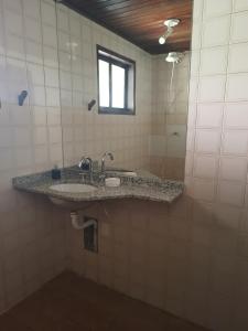 ein Badezimmer mit Waschbecken und Fenster in der Unterkunft Casa Riviera in Bertioga