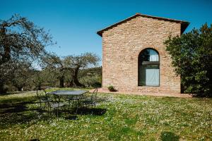 een tafel en stoelen voor een bakstenen gebouw bij Agriturismo Montalbino in Montespertoli
