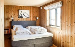 a bedroom with a bed with wooden walls and a window at 4 Bedroom Beautiful Home In yer in Øyer