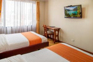 a room with two beds and a desk with a window at Hotel Splendor by Friends Company in Bogotá +188 photos