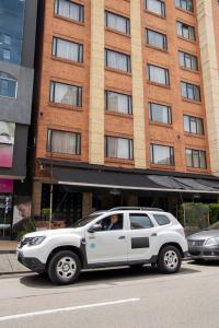 una camioneta blanca estacionada frente a un edificio en Hotel Splendor by Friends Company, en Bogotá