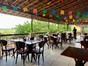 a restaurant with tables and chairs on a patio at Gravatá Flat no condomínio Monte Castelo MELHOR LOCALIZAÇÃO , Wi-Fi, SKY e AR in Gravatá