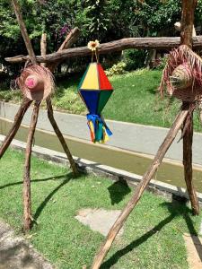 Eine hölzerne Figur, die einen Drachen im Gras hält in der Unterkunft Gravatá Flat no condomínio Monte Castelo MELHOR LOCALIZAÇÃO , Wi-Fi, SKY e AR in Gravatá