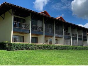 ein großes Gebäude mit grünem Rasen davor in der Unterkunft Gravatá Flat no condomínio Monte Castelo MELHOR LOCALIZAÇÃO , Wi-Fi, SKY e AR in Gravatá