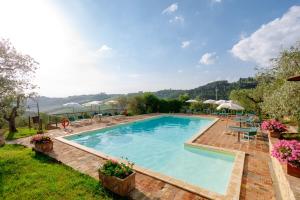 a large swimming pool with tables and umbrellas at Agriturismo Montalbino in Montespertoli