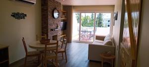 een woonkamer met een tafel en stoelen en een bank bij Blue & Yellow Penthouse with Terrace at Balaia Mar in Albufeira