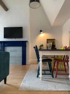 a living room with a table and a tv at Bespoke Luxury Serviced Apartment in Macclesfield