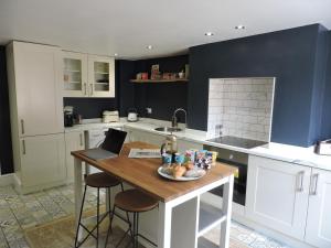 a kitchen with a table with a laptop on it at Bespoke Luxury Serviced Apartment in Macclesfield