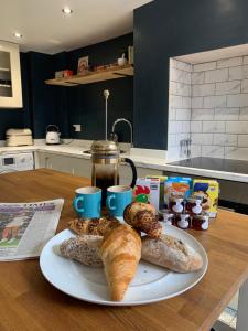 un plato de pan y bollería en una mesa en Bespoke Luxury Serviced Apartment, en Macclesfield