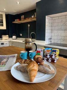 a plate of bread and pastries on a table at Bespoke Luxury Serviced Apartment in Macclesfield