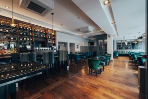 a restaurant with green chairs and a bar at The Fitzwilton Hotel in Waterford