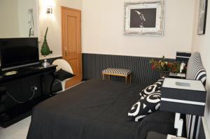ローマにあるスイートドリームズ インのベッドとテレビが備わるホテルルームです。
