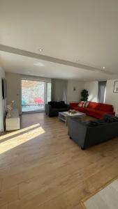 Woolwichにある3 bed apartment in London Plumsteadの広いリビングルーム(赤いソファ、テーブル付)