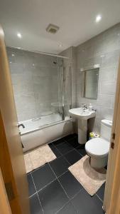 La salle de bains est pourvue de toilettes, d'une baignoire et d'un lavabo. dans l'établissement 3 bed apartment in London Plumstead, à Woolwich