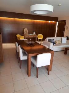 a dining room with a wooden table and white chairs at Salgados by The Beach in Albufeira