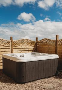 a hot tub sitting in front of a wooden fence at The Herdsman's House in Thurso