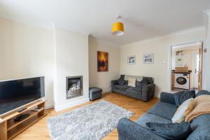 a living room with a couch and a tv at Seaside cottage in Maryport
