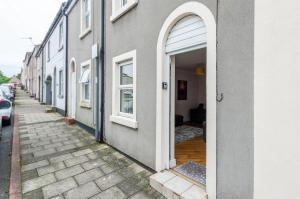 an open door of a building on a street at Seaside cottage in Maryport