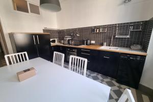 a kitchen with a white table and a black refrigerator at The zenitude of Shepherds #DO in Grenoble