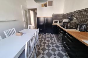 a kitchen with a black and white checkered floor at The zenitude of Shepherds #DO in Grenoble