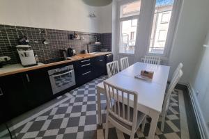 a kitchen with a white table and chairs in a room at The zenitude of Shepherds #DO in Grenoble