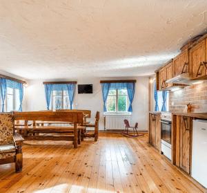 a kitchen with a table and a wooden floor at Čertův mlýn - pohádková chalupa - Jizerské hory in Weissbach