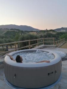 a man in a jacuzzi tub on a patio at CASA LINARA in Frontino