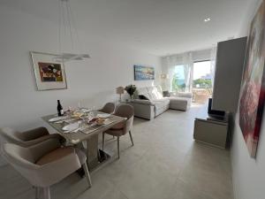 una sala de estar blanca con mesa y sillas en New build modern ap 4 min walk to the beach and Marbella old town, en Marbella