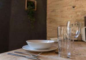 a table with a bowl and two glasses on it at Magnifique Triplex avec Sauna Plein Centre Ville in Metz