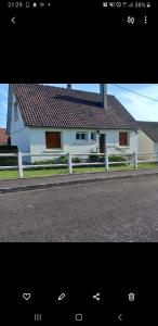 una casa blanca con una valla al lado de una carretera en Gîte paisible, 