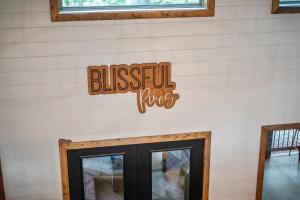 a wall with a sign that reads blissful fires at Blissful Pines in Broken Bow